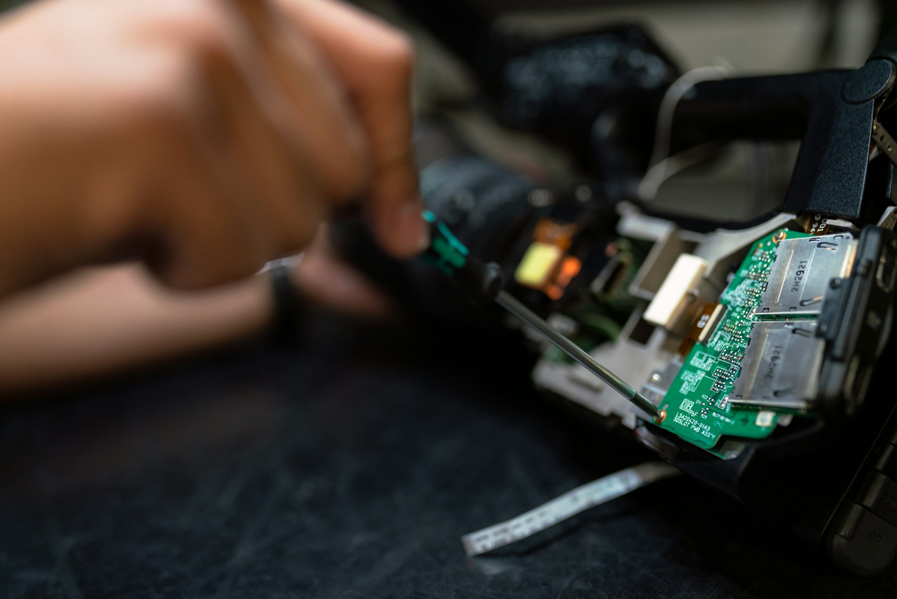 Szervizes kézzel javítja egy elektronikai készülék áramkörét.